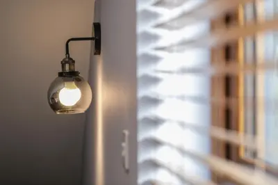 a light bulb hanging on a wall next to a window at Oak View Lodge Luxury Master Studio near Ipswich & Woodbridge in Playford