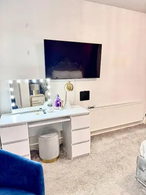 a white desk with a mirror and a blue chair at Deluxe Spacious King Size Room in Hornchurch