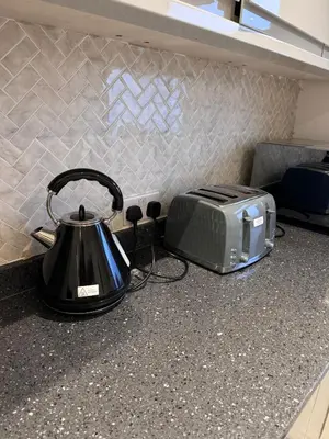 a tea kettle and a toaster on a kitchen counter at Deluxe Spacious King Size Room in Hornchurch