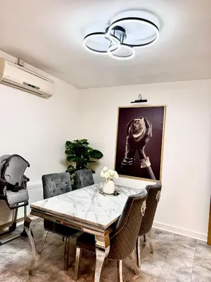 a dining room with a table and chairs at Deluxe Spacious King Size Room in Hornchurch
