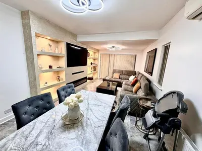 a living room with a table and a couch at Deluxe Spacious King Size Room in Hornchurch