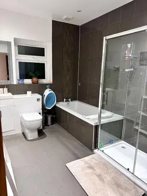 a bathroom with a tub and a toilet and a shower at Deluxe Spacious King Size Room in Hornchurch