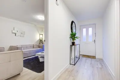 a white living room with a couch and a mirror at Entire house in Stanway, Colchester in Colchester