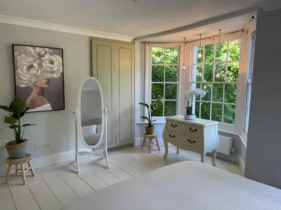 a bedroom with a bed and a dressing table and a mirror at Elegant Victorian house - very best central location in historical city centre in Cambridge