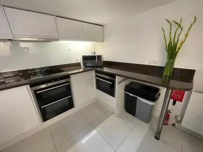 a kitchen with white cabinets and a vase on a counter at Elegant Victorian house - very best central location in historical city centre in Cambridge