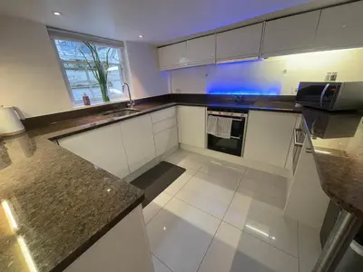 a kitchen with white cabinets and a counter top at Elegant Victorian house - very best central location in historical city centre in Cambridge