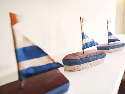 three small wooden boats sitting on a table at 6 Town Steps by The Suffolk Cottage Collection in Aldeburgh