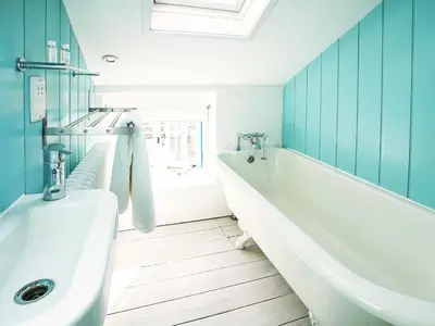 a bathroom with a tub and a toilet and a sink at 6 Town Steps by The Suffolk Cottage Collection in Aldeburgh