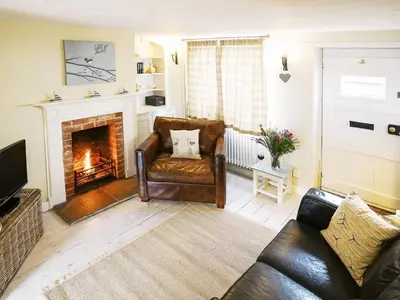 a living room with a couch and a fireplace at 6 Town Steps by The Suffolk Cottage Collection in Aldeburgh