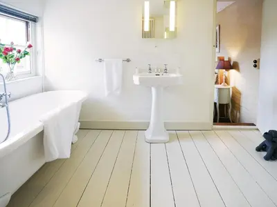 a white bathroom with a tub and a sink at Hidden Cottage by The Suffolk Cottage Collection in Aldeburgh