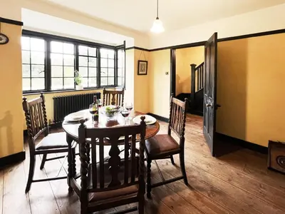 a dining room with a wooden table and chairs at The Vintage House by The Suffolk Cottage Collection in Aldeburgh