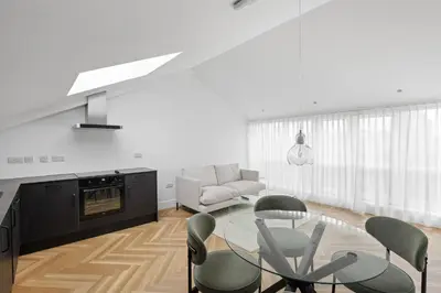 a living room with a glass table and chairs at Navigation Yard in Chelmsford