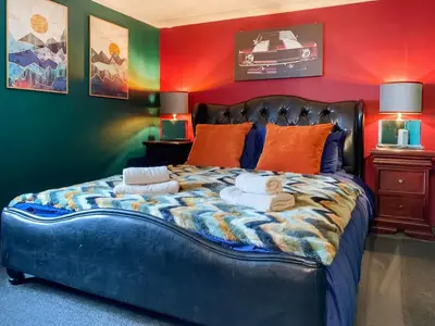 a bedroom with a large bed with colorful walls at The Fox - Uk48554 in Colchester