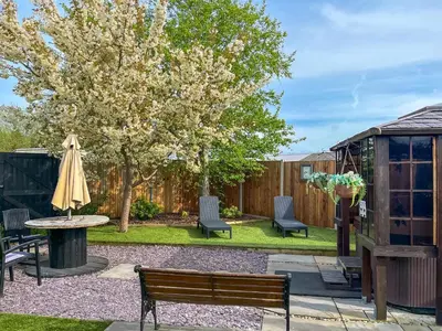 a backyard with a bench and a table and a tree at The Fox - Uk48554 in Colchester