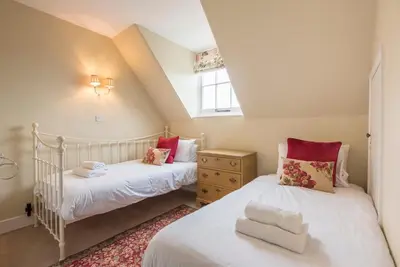 two beds in a small room with a window at Castle Cottage, Orford in Orford