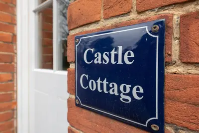 a sign on the side of a brick building at Castle Cottage, Orford in Orford