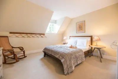 a bedroom with a bed and a chair at Castle Cottage, Orford in Orford