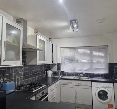 a kitchen with a sink and a stove top oven at Cosy large double room in Basildon
