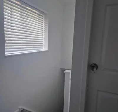 a bathroom with a window with blinds on a door at Cosy large double room in Basildon