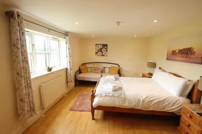 a bedroom with a bed and a window at The Eelsfoot inn in Theberton