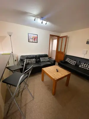 a living room with a black couch and a coffee table at Two Bedroom Bungalow No2 - Secure Gated Parking in Basildon