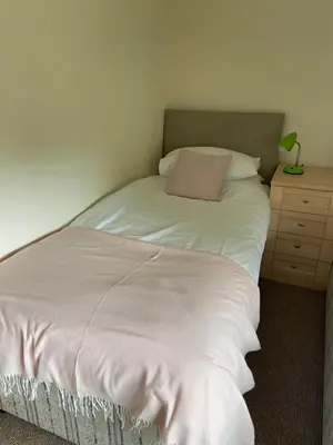 a bed with a pillow and a dresser in a room at Two Bedroom Bungalow No2 - Secure Gated Parking in Basildon