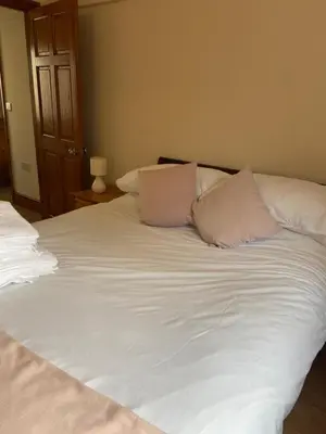 a large white bed with two pillows on it at Two Bedroom Bungalow No2 - Secure Gated Parking in Basildon
