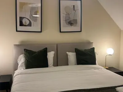 a bedroom with a bed with two pictures on the wall at Grange Luxe 4 in Martlesham Heath