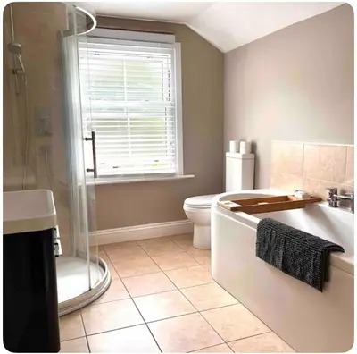 a bathroom with a tub and a toilet and a window at Tardis Vibes in Stowmarket