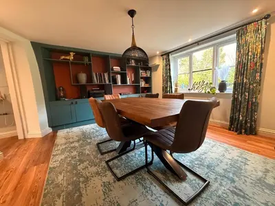 a dining room with a wooden table and chairs at The Old Coach House in Hockwold cum Wilton