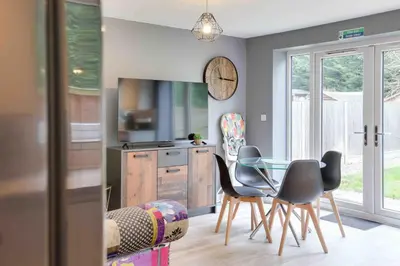 a kitchen with a glass table and chairs at Blackwater Villa Witham in Witham
