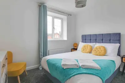 a bedroom with a bed with two towels on it at Blackwater Villa Witham in Witham