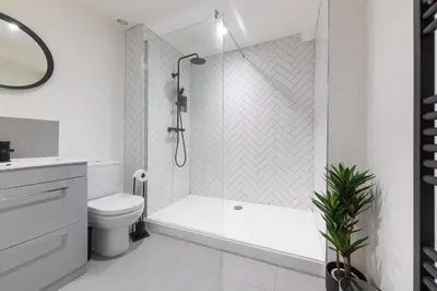 a white bathroom with a tub and a toilet at Flat in Royston Town Centre in Royston