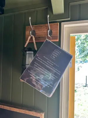 a sign hanging on a wall next to a door at Secret Paddock Shepherds Hut in Hollesley