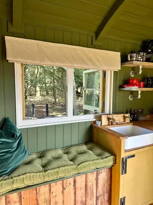 a kitchen with a window and a bench next to a sink at Secret Paddock Shepherds Hut in Hollesley