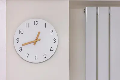 a clock hanging on a white wall at Modern 2 Bed Gem Southend on Sea Free parking in Southend-on-Sea