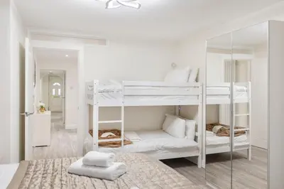 a bedroom with two bunk beds with towels on the bed at Modern 2 Bed Gem Southend on Sea Free parking in Southend-on-Sea
