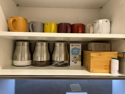a shelf with a bunch of coffee pots and a box at The Belles' Place near Colchester in Earls Colne