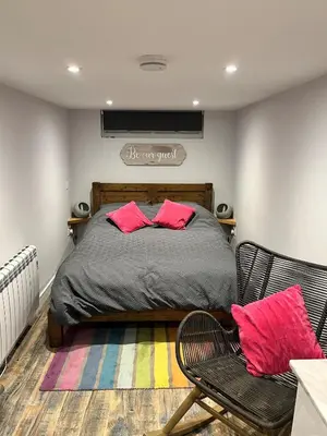 a bedroom with a bed with two pink pillows on it at Brightons view in Saxlingham Thorpe