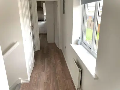 a hallway with a wooden floor and a window at Detached Place to stay in Essex in Witham