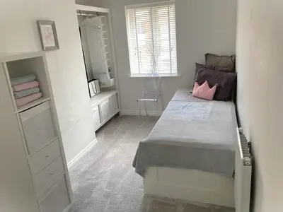 a small bedroom with a bed and a mirror at Detached Place to stay in Essex in Witham