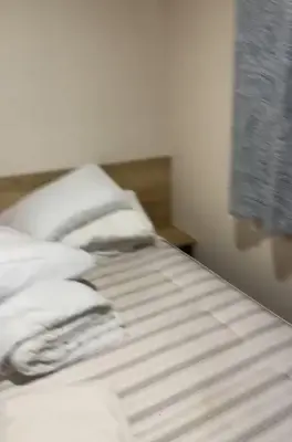 a white bed with white sheets and a window at 911 Caravan in Saint Osyth