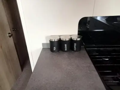 three black trash cans sitting next to a piano at 911 Caravan in Saint Osyth