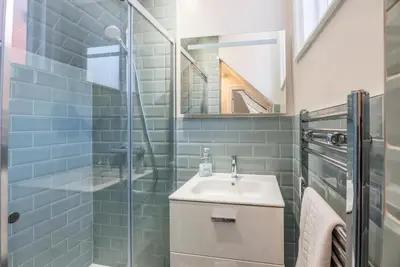 a bathroom with a sink and a glass shower at The Book Nook, Woodbridge in Woodbridge