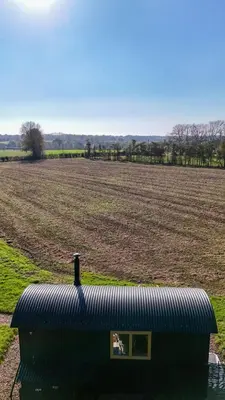 a black tank in front of a large field at 'Bramley' Hut on private farm in Charsfield