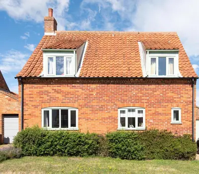 a brick house with white windows and a roof at 2 Admirals Walk by Aldeburgh Coastal Cottages in Thorpeness