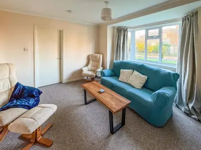 a living room with a blue couch and a table at Lowal House - Uk46054 in Saffron Walden