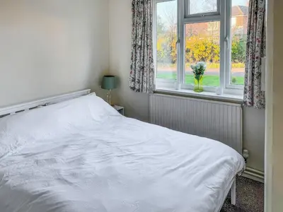 a white bed in a bedroom with a window at Lowal House - Uk46054 in Saffron Walden