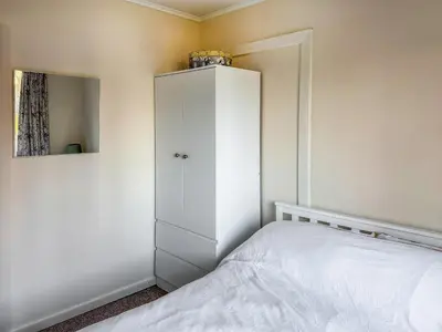 a bedroom with a white cabinet and a bed at Lowal House - Uk46054 in Saffron Walden