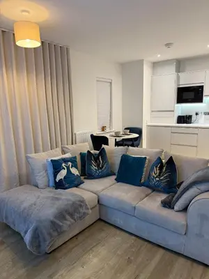 a living room with a couch with blue pillows at Prestige 1 bed apartment in Shenfield